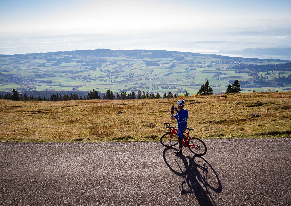 One male cyclist taking a photo of Lake Biel from the climb to Mont Chasseral in Kanton Bern, Switzerland