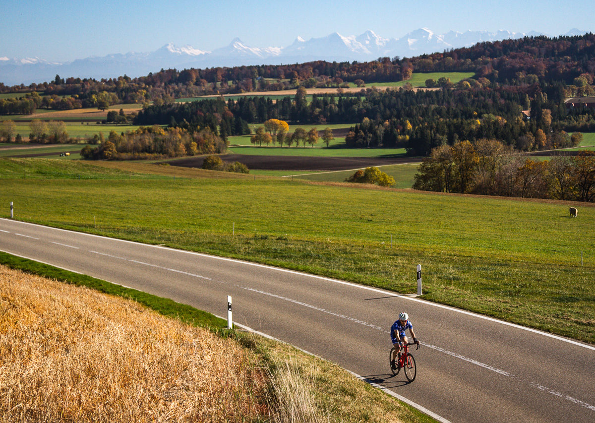 One man riding in the Jura region of Kanton Bern, Switzerland with the Alps in the background