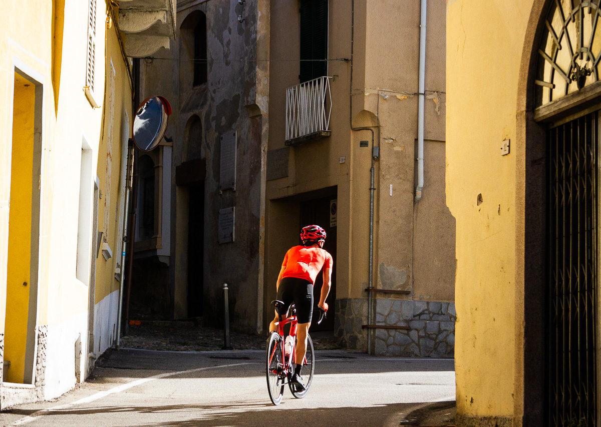 One male cyclist riding in a village along Lago Maggiore in Provincia di Varese, Italy