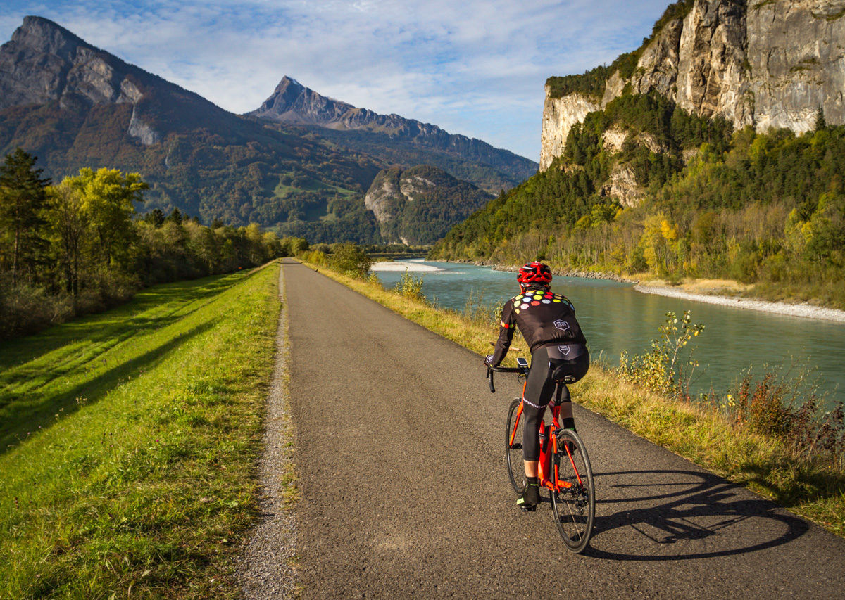 One male cyclist riding along the Rhine river in Kanton Grabünden, Switzerland