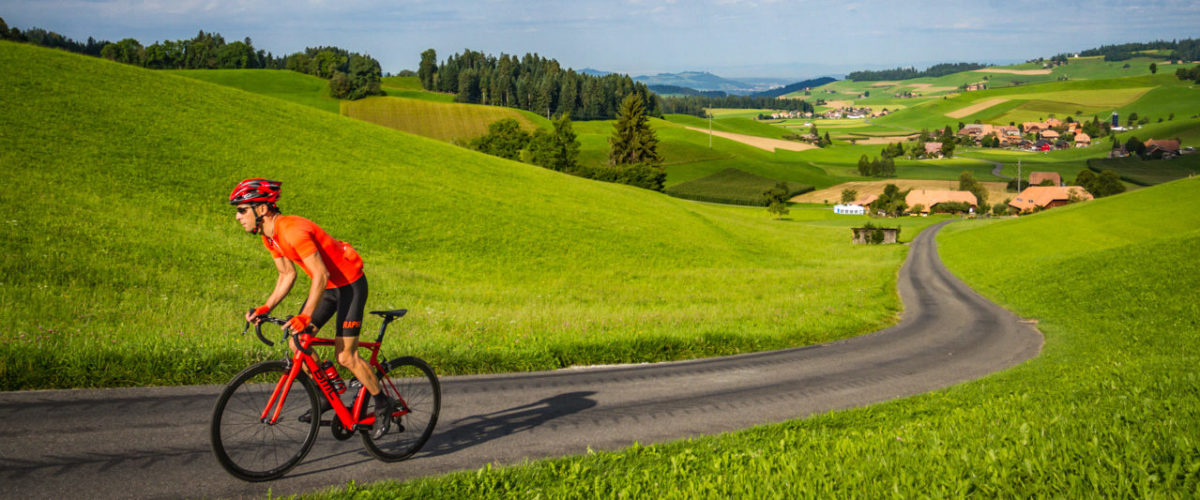 Emmental-8889 One male cyclist climbing out of Ami in the Emmental region of Kanton Bern, Switzerland