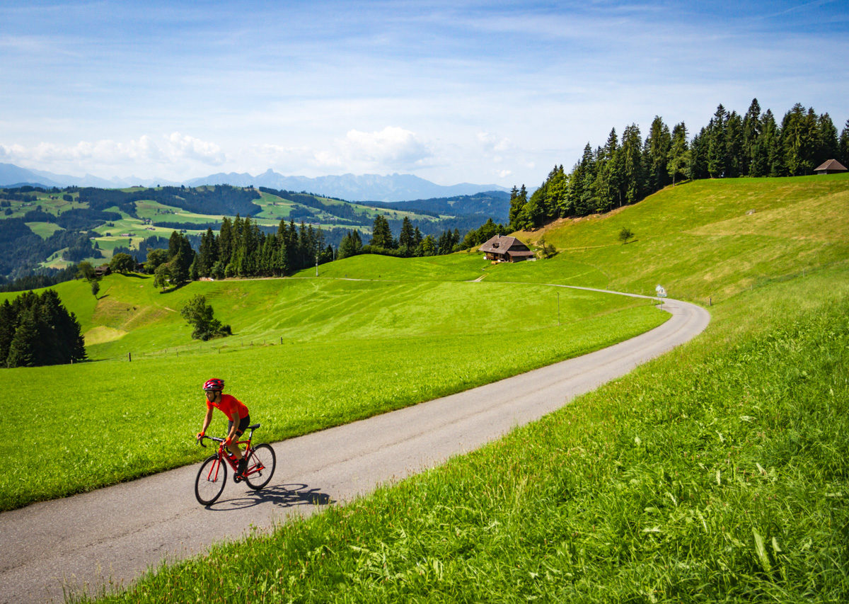 One male cyclist riding in the Emmental region of Kanton Bern, Switzerland One male cyclist riding in the Emmental region of Kanton Bern, Switzerland