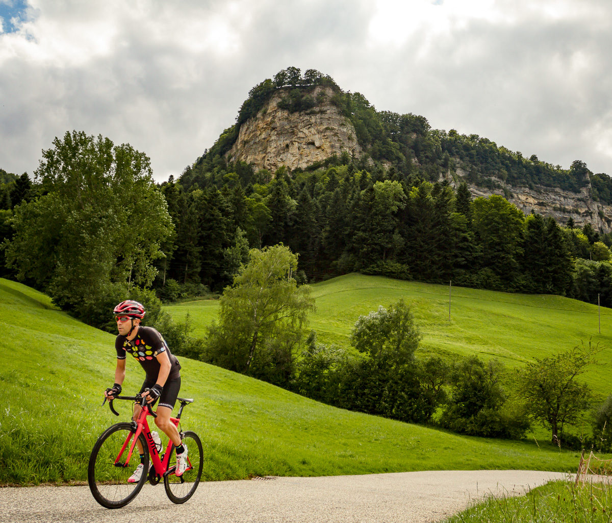 Switzerland Tourism-7407 One male cyclist climbing Belchenpass (Jura mountains) in Kanton Baselland, Switzerland