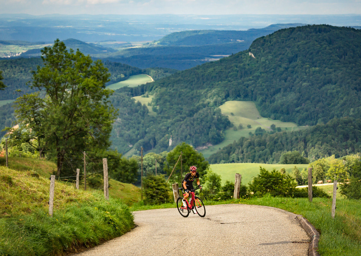 Switzerland Tourism-7541 One male cyclist climbing Belchenpass (Jura mountains) in Kanton Baselland, Switzerland